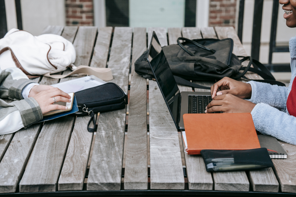 Two motivated entrepreneurial women working on their laptops, and phones with their planners and bags next to them. With the help of The Freckled Strawberry, a non-profit that encourages and teaches independence of women, these two women are well on their way to be well versed in all matters of finance, independence, entrepreneurship, and, investing, budgeting and wealth creation.